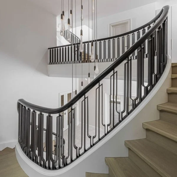 Custom curved wrought iron staircase railing with a modern U-shaped geometric pattern and dark handrail in a bright, luxury interior.